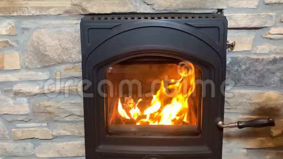 一位喝茶的女士在一个黑色的壁炉里双手温暖着明亮的橙色火焰舒适的家庭概念视频的预览图