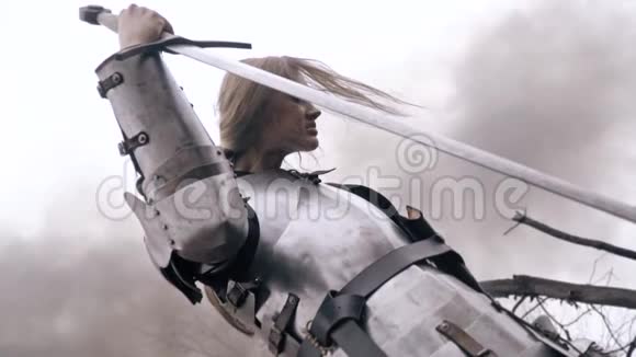 一个穿着中世纪盔甲的女人正靠在剑上低头视频的预览图
