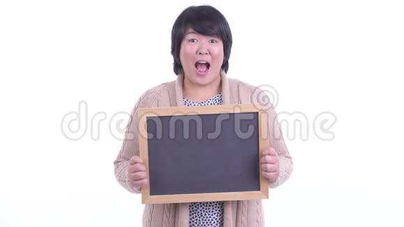 令人惊讶的超重亚洲女人拿着黑板准备过冬视频的预览图