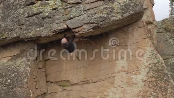 一个强壮的人在陡峭的悬崖上走一条艰难的路线视频的预览图