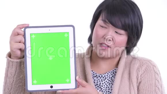 一张快乐超重的亚洲女人的脸展示为冬天准备好的数字平板电脑视频的预览图