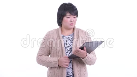 快乐超重的亚洲女人用剪贴板面试准备过冬视频的预览图