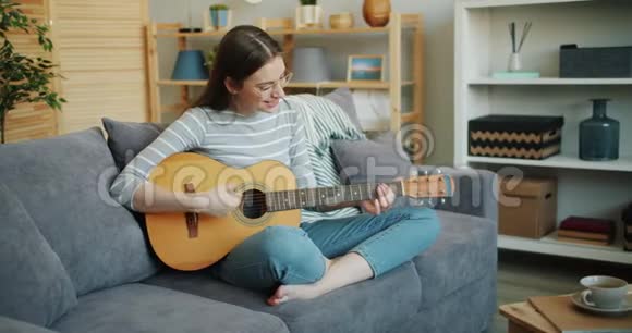 戴眼镜的美女弹吉他坐在沙发上摆莲花姿势视频的预览图