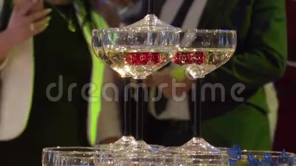 装饰精美的香槟酒杯摆在桌子上里面有一个红樱桃一个婚礼庆典视频的预览图