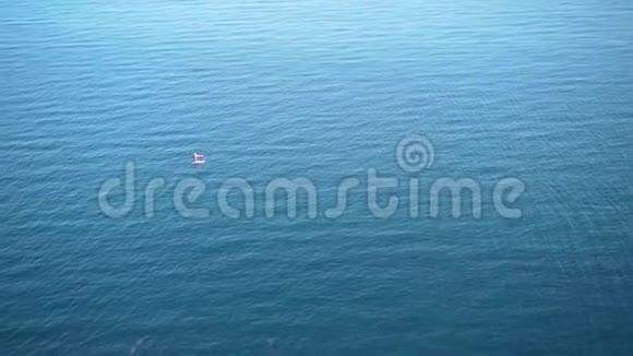 两名冲浪者在绿松石波海的冲浪板上漂浮鸟瞰圆视图视频的预览图