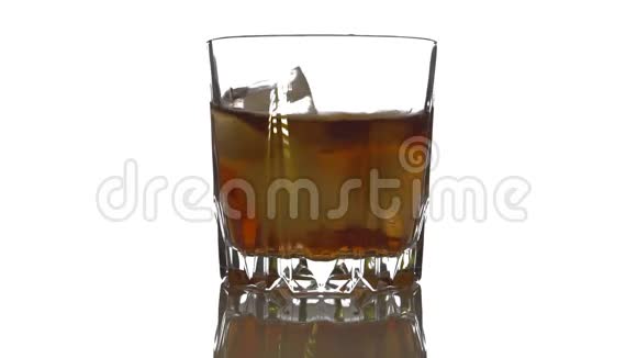 特写镜头冰块在一杯威士忌中旋转融化孤立于白色背景视频的预览图