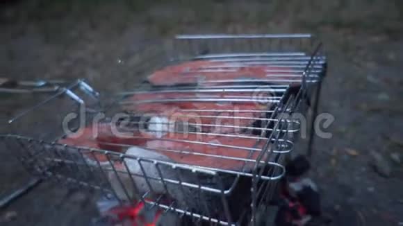 三文鱼在木桩上在烧烤架上煮红鱼烧烤菜品概念视频的预览图