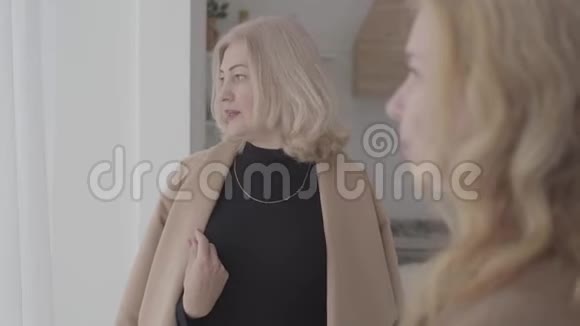 一个严肃的白人女人和她的朋友说话微笑的肖像积极成熟的女人讨论她们的生活视频的预览图