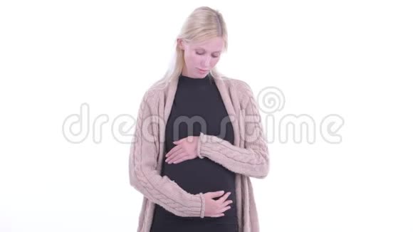一位年轻的金发孕妇在思考低头看着视频的预览图