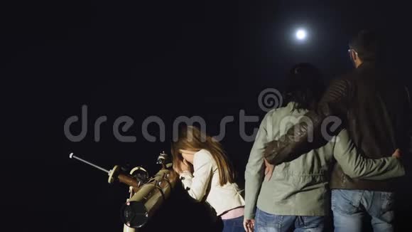 幸福的一家人晚上用望远镜看月亮视频的预览图