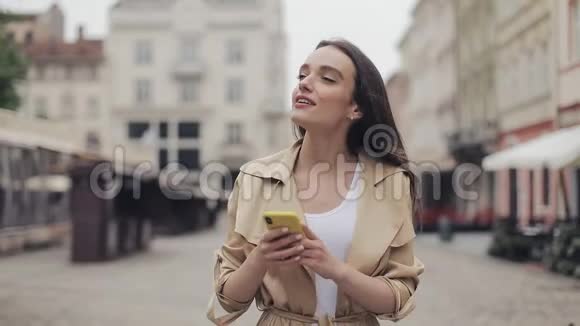 美丽的年轻旅游女士在城市的大街上散步看上去快乐而轻松拍摄照片的女人视频的预览图