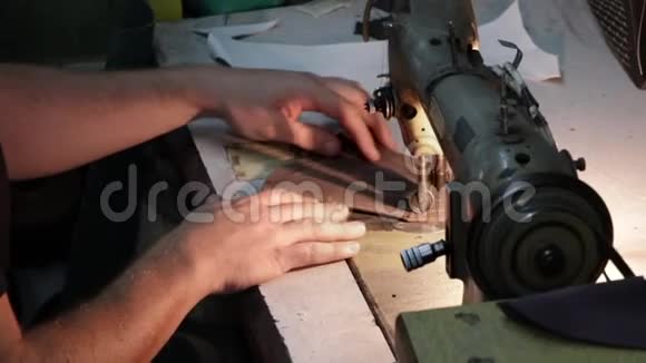 男鞋匠手用旧缝纫机缝制皮革视频的预览图