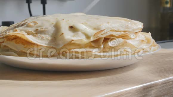 黄油会融化在热薄饼上而热薄饼是站在白色盘子里的金煎饼看上去很开胃视频的预览图