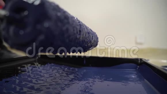 关闭油漆滚筒掉下来的镜头蓝色油漆滴从特殊油漆工具视频的预览图