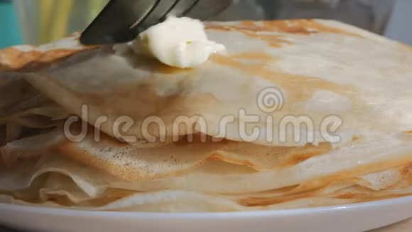 俄罗斯煎饼新鲜的热金色它们被日光照亮在煎饼上放一块黄油黄油视频的预览图