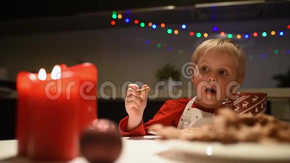 可爱的小男孩在假期吃自制的饼干喝热可可圣诞节和新年有孩子视频的预览图