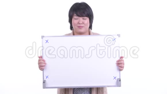 快乐超重的亚洲女人拿着白板得到冬天的好消息视频的预览图