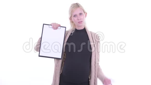 一位年轻的金发碧眼的孕妇展示着剪贴板竖起大拇指视频的预览图