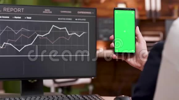 商人用绿色屏幕工作手机的背面视图视频的预览图