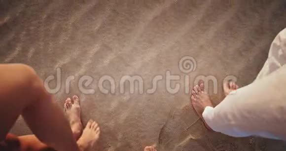 浪漫的时光细节一对夫妇牵着手走过海滩他们有赤脚和白色的着装规定视频的预览图