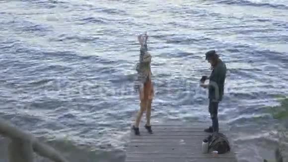 穿着格子衬衫的希普斯特千禧旅游夫妇站在码头上在海上享受旅行的背景下聊天视频的预览图
