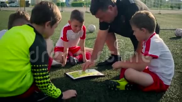 少年足球队教练展示儿童游戏计划视频的预览图