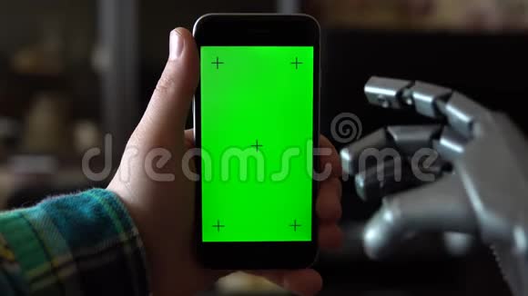 赛博格用电话灰色机械手滑动智能手机与绿色屏幕铬钥匙视频的预览图
