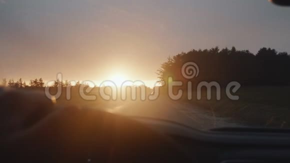 令人难以置信的POV拍摄的司机手握着汽车方向盘朝着秋日日落乡间道路缓慢行驶视频的预览图