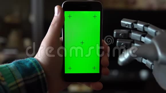 赛博格用电话灰色机械手刷上智能手机与绿色屏幕铬钥匙视频的预览图