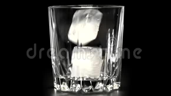 冰块在黑色背景下落入玻璃中慢动作鸡尾酒概念5视频的预览图