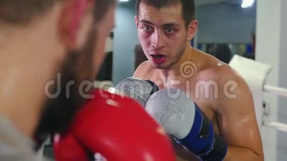 拳击训练两名带口哨的出汗男子在拳击场上进行激烈的战斗视频的预览图