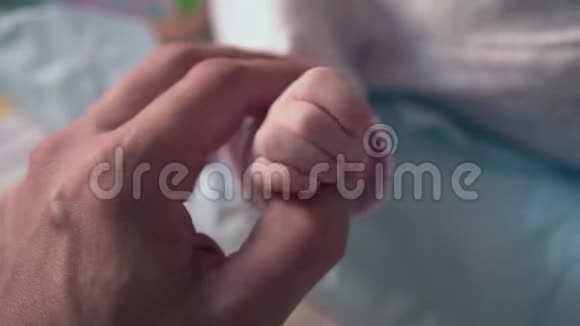 一只成年雄性手牵着一只小婴儿的手这个概念是对父母的关心和保护是一个幸福的童年视频的预览图