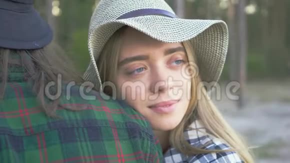 年轻白种人的特写镜头微笑着看着远方一对游客在森林里休息视频的预览图