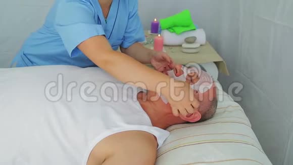 女性美容师从男人的脸上移除保湿面膜视频的预览图