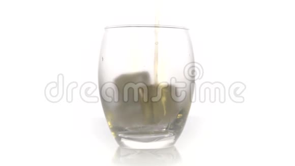 金色威士忌倒入玻璃将威士忌或白兰地倒入带有白色背景冰块的玻璃杯中视频的预览图