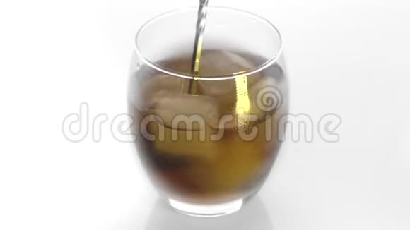 特写镜头冰块在一杯威士忌中旋转融化孤立在白色背景上在威士忌中旋转冰块视频的预览图