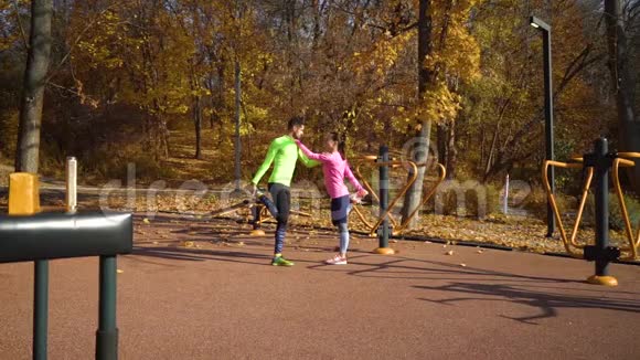 在秋天的运动场上情侣们互相抱着伸腿视频的预览图