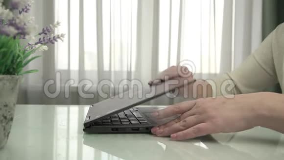 女士双手打开笔记本打字坐在白色桌子上视频的预览图