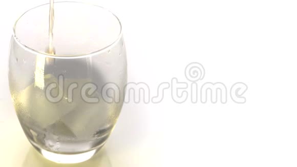 金色威士忌倒入玻璃将威士忌或白兰地倒入带有白色背景冰块的玻璃杯中视频的预览图
