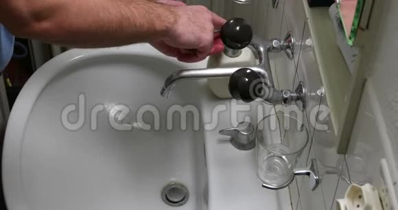 白色男洗手用液体肥皂在浴室洗手池俯视无脸流水视频的预览图