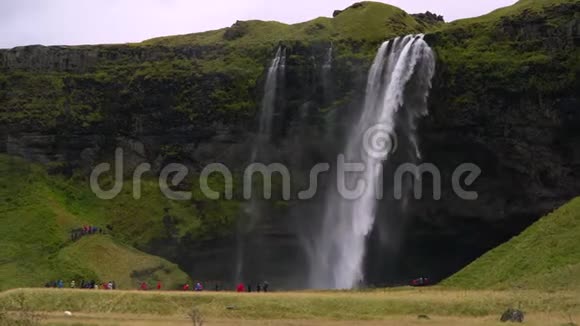 游客穿着雨衣在瀑布附近视频的预览图