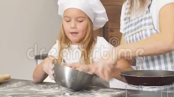 勤奋的女孩和女儿把面团揉进铁碗里想做一个美味的蛋糕视频的预览图