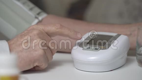 老人按下桌子上血压监测器的按钮视频的预览图