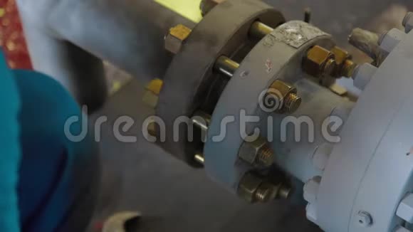 工人用扳手拧紧螺栓工人在工业厂房装配油气设备小组计量视频的预览图