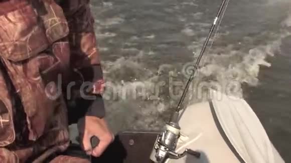 渔夫用马达控制一艘充气船在湖边钓鱼视频的预览图