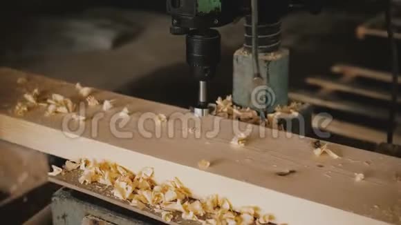近距离男性手拿木板覆盖锯末远离钻床工具制造慢动作视频的预览图
