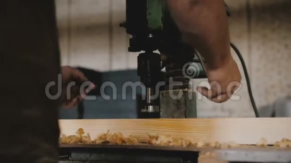 特写男手钻木木板用专业机床在一家工厂木匠工作时动作慢视频的预览图