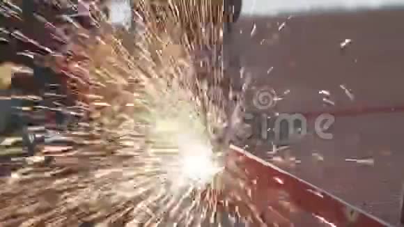男性手用角磨机切断金属毛坯片在建筑中切割带有火花的钢视频的预览图
