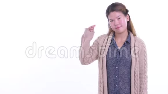 快乐的年轻亚洲女人拍打手指展示准备过冬的东西视频的预览图