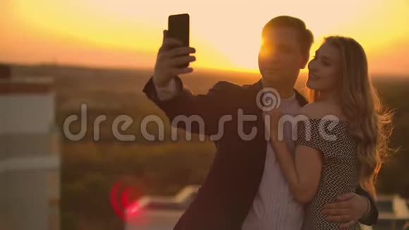 两个情人一男一女笑着在手机上拍照自拍慢镜头自拍夏日一起视频的预览图